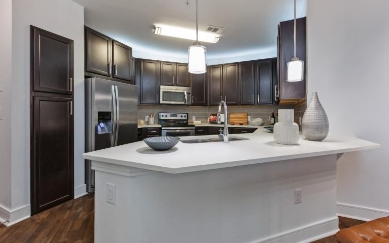 a kitchen with black cabinets and a white counter island