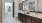 a bathroom with a large mirror and twin sinks and closet access