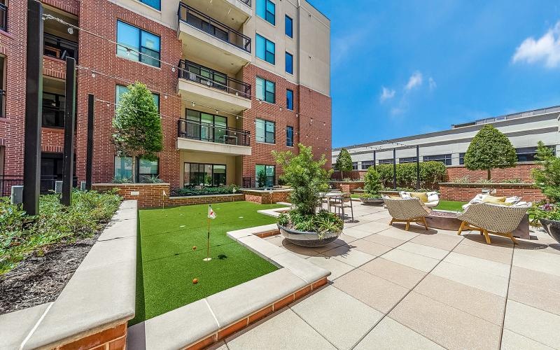a courtyard with chairs and tables and putt putt