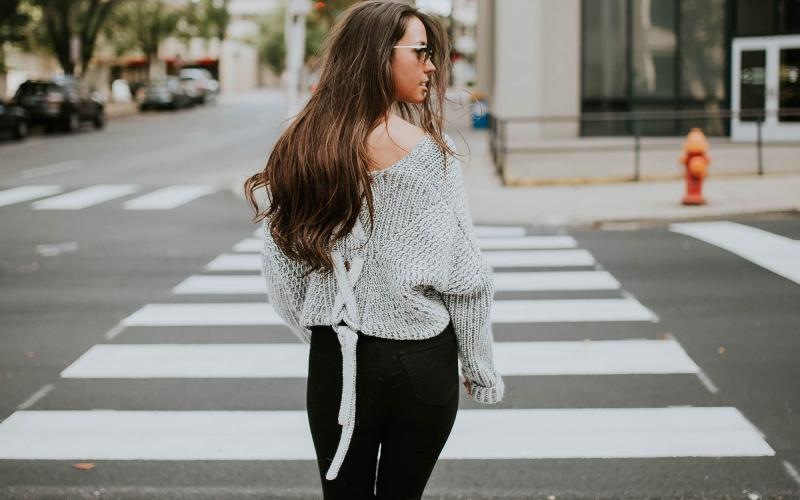 Close to the center of everything a person walking in a crosswalk