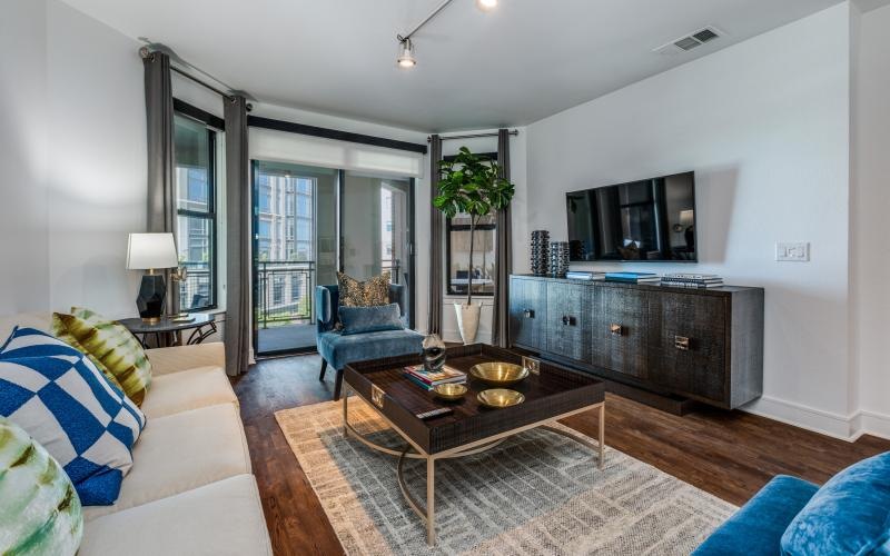 a living room with a couch and a table and windows